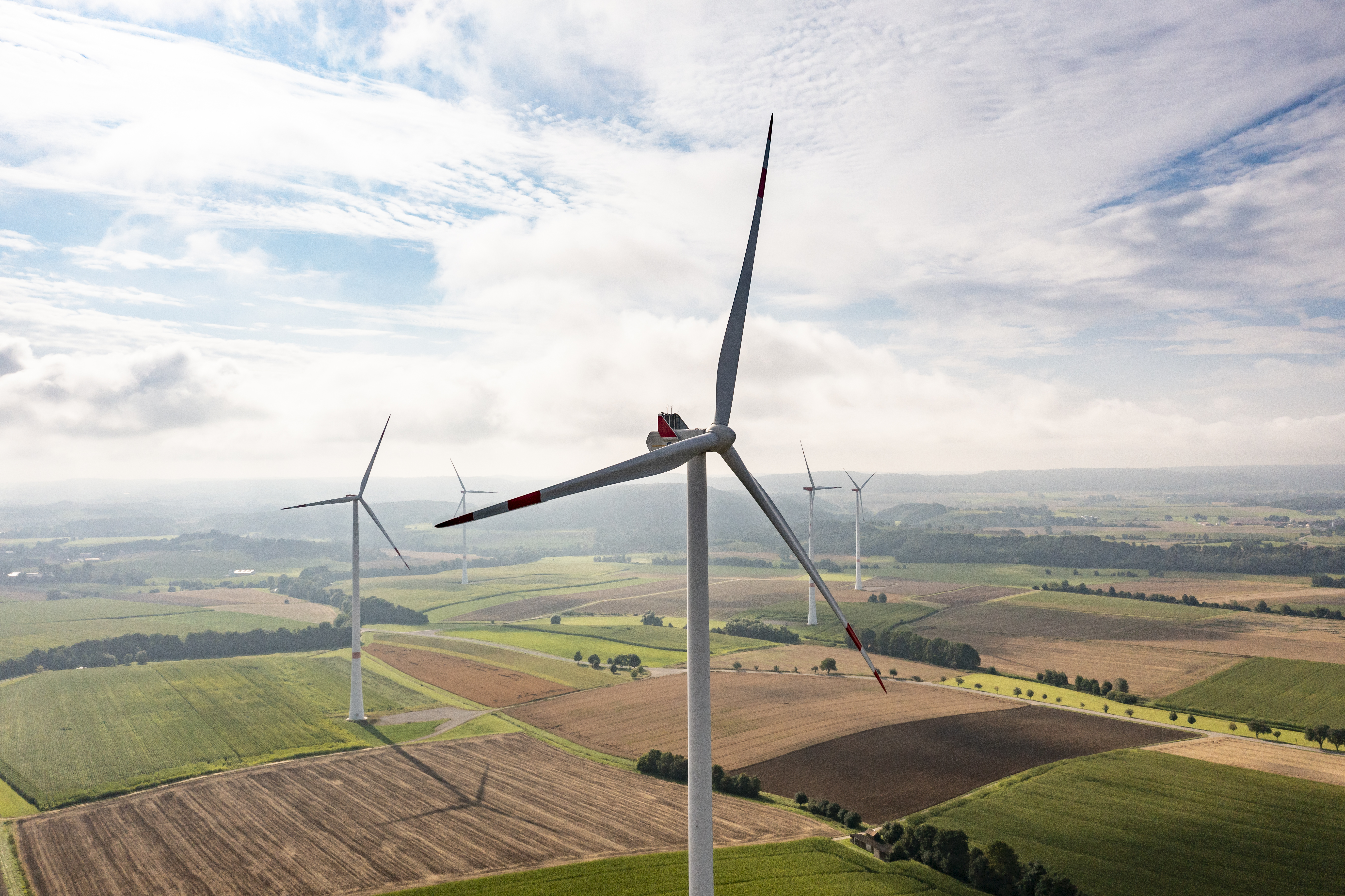 Fünf Windräder bei bewölktem Himmel.