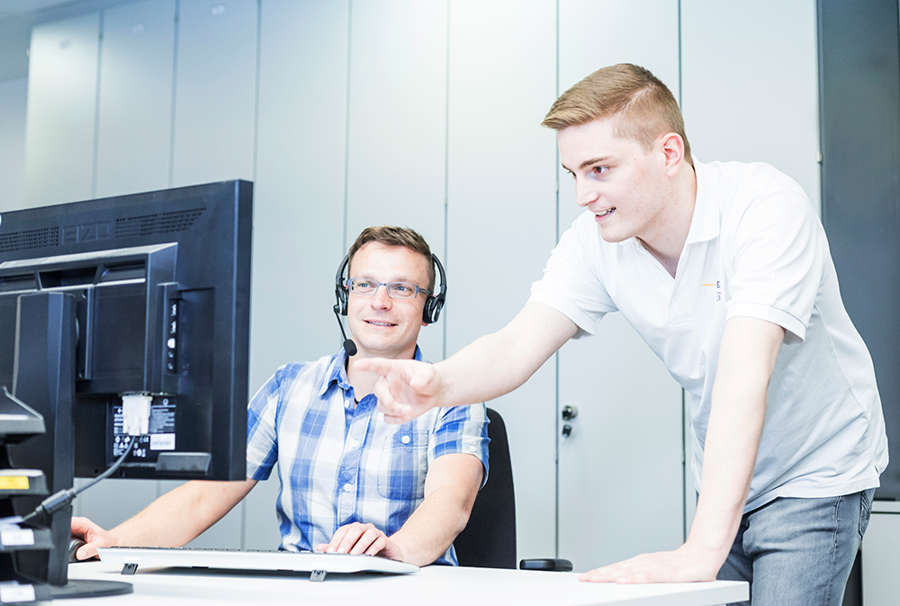 Zwei Mitarbeiter der ODR sprechen vor einem Bildschirm miteinander