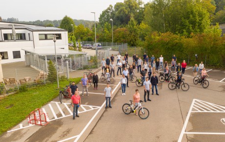 Personen stehen auf Parkplatz.