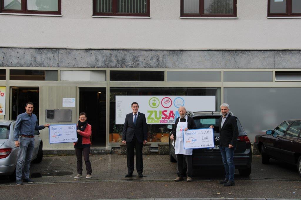 Spende Giengen Vor einem Laden stehen 4 Personen.