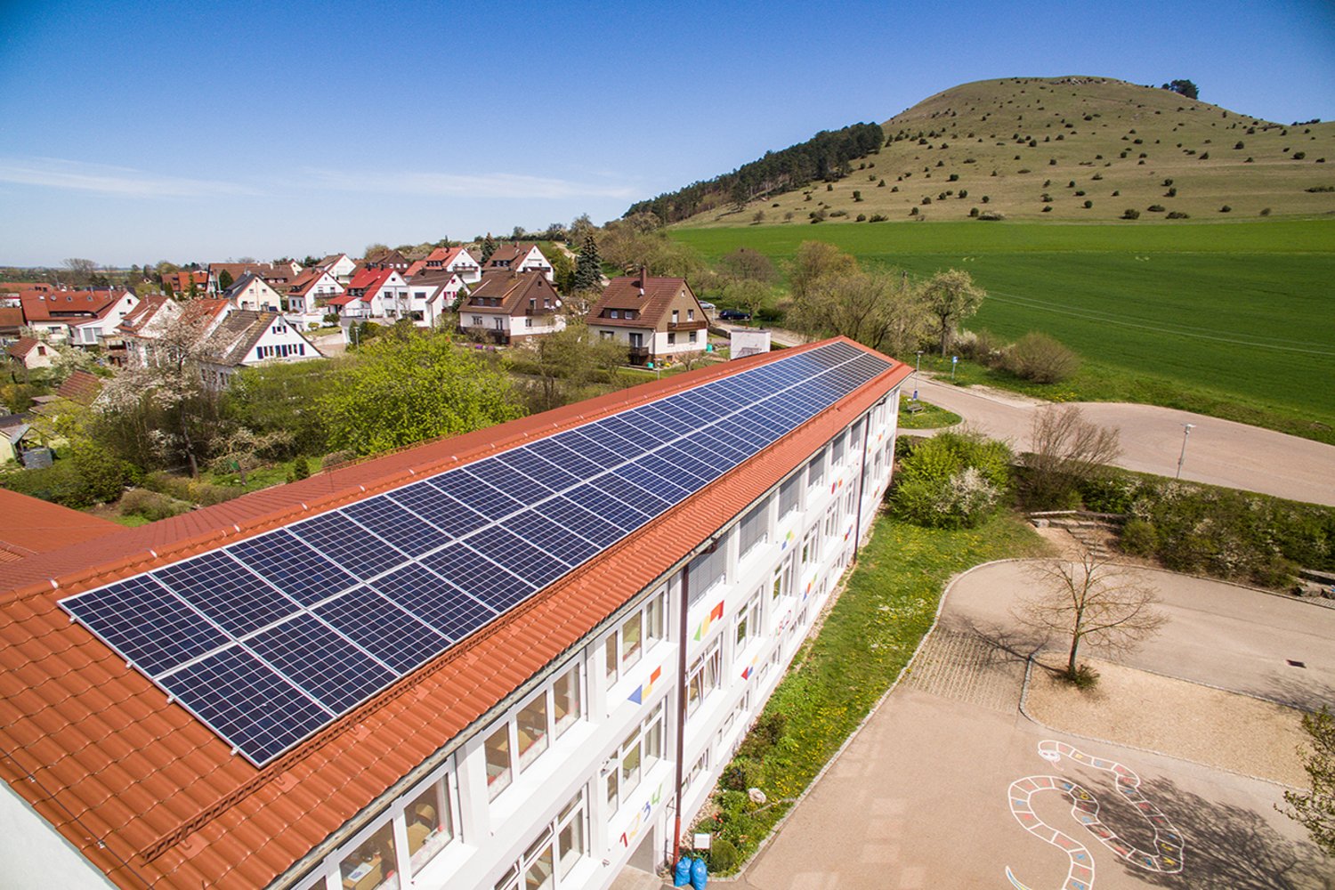 Schuldach mit PV-Anlage, im Hintergrund der Ipf