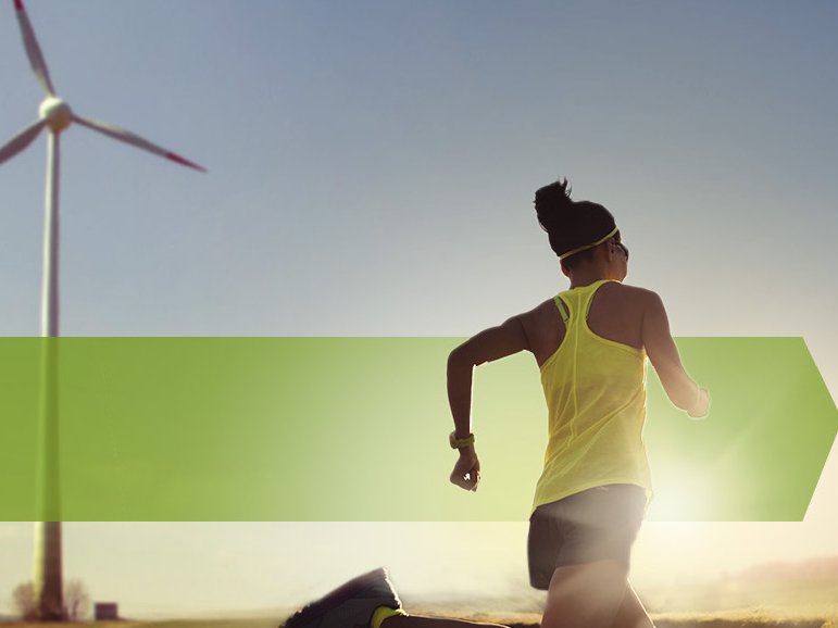 Frau joggt an einem Windrad vorbei 