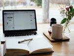 Arbeitsplatz mit Laptop und Notizbuch