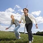 Frau und Mann rennen vor Windrad