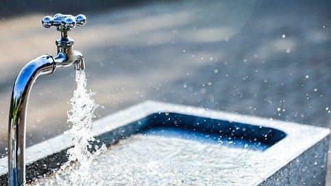 Wasser spritz aus Wasserhahn bei einem Brunnen 