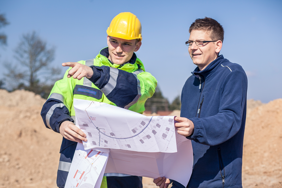 Baustelle Planung Zwei Mitarbeiter schauen sich gemeinsam einen Bauplan an