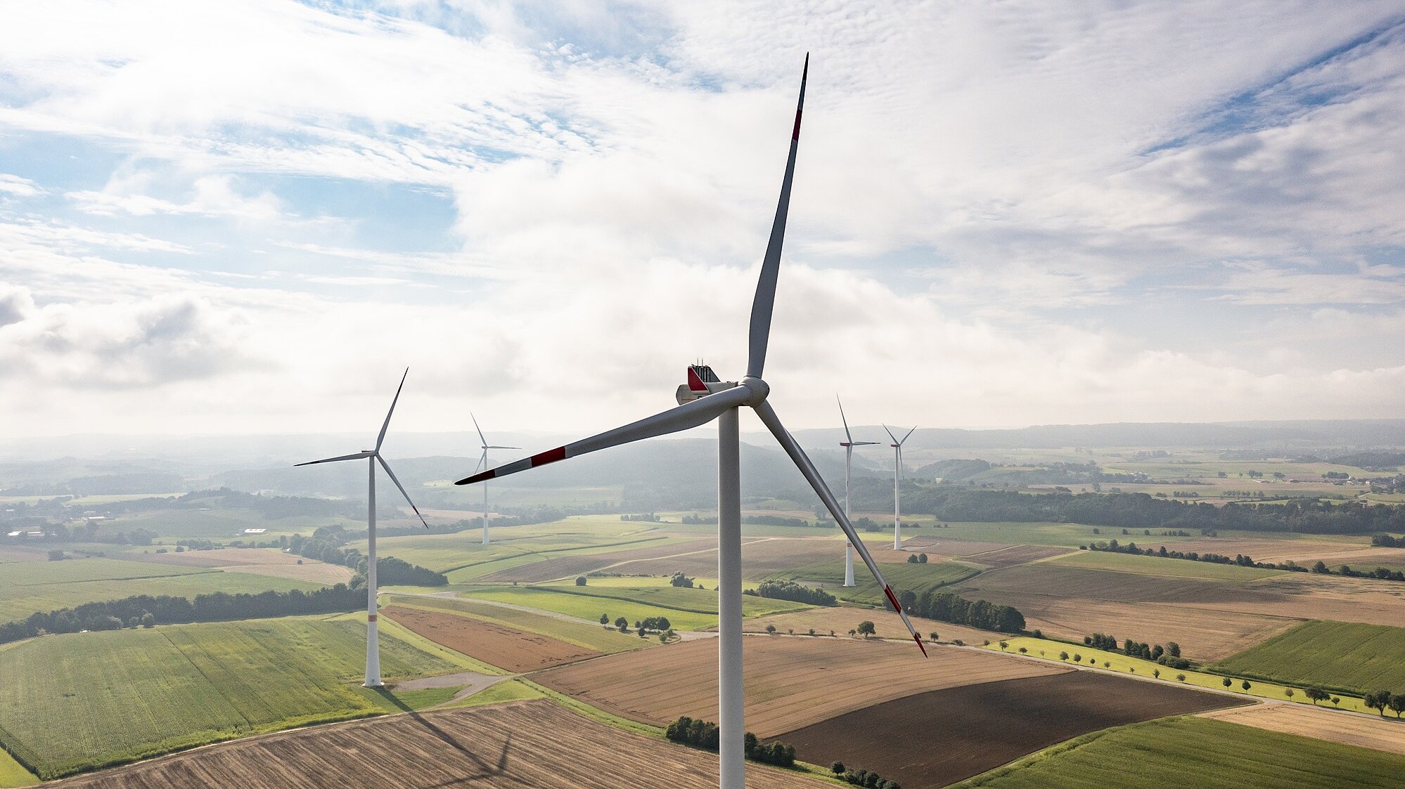 Fünf Windräder bei bewölktem Himmel.