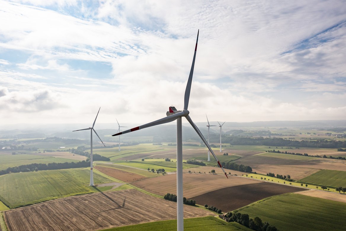Fünf Windräder bei bewölktem Himmel.