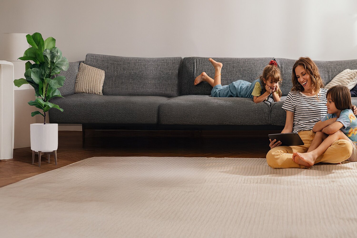 Eine Familie zu Hause im Wohnzimmer mit einem Tablet