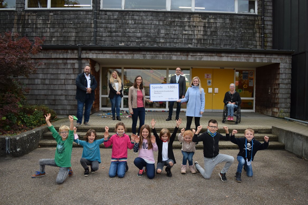 Spende Förderverein Neunheim Kinder und Erwachsene stehen vor Schule.