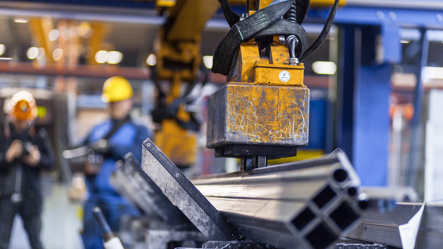 Zwei Männer überwachen eine Maschine beim Arbeiten mit Metall